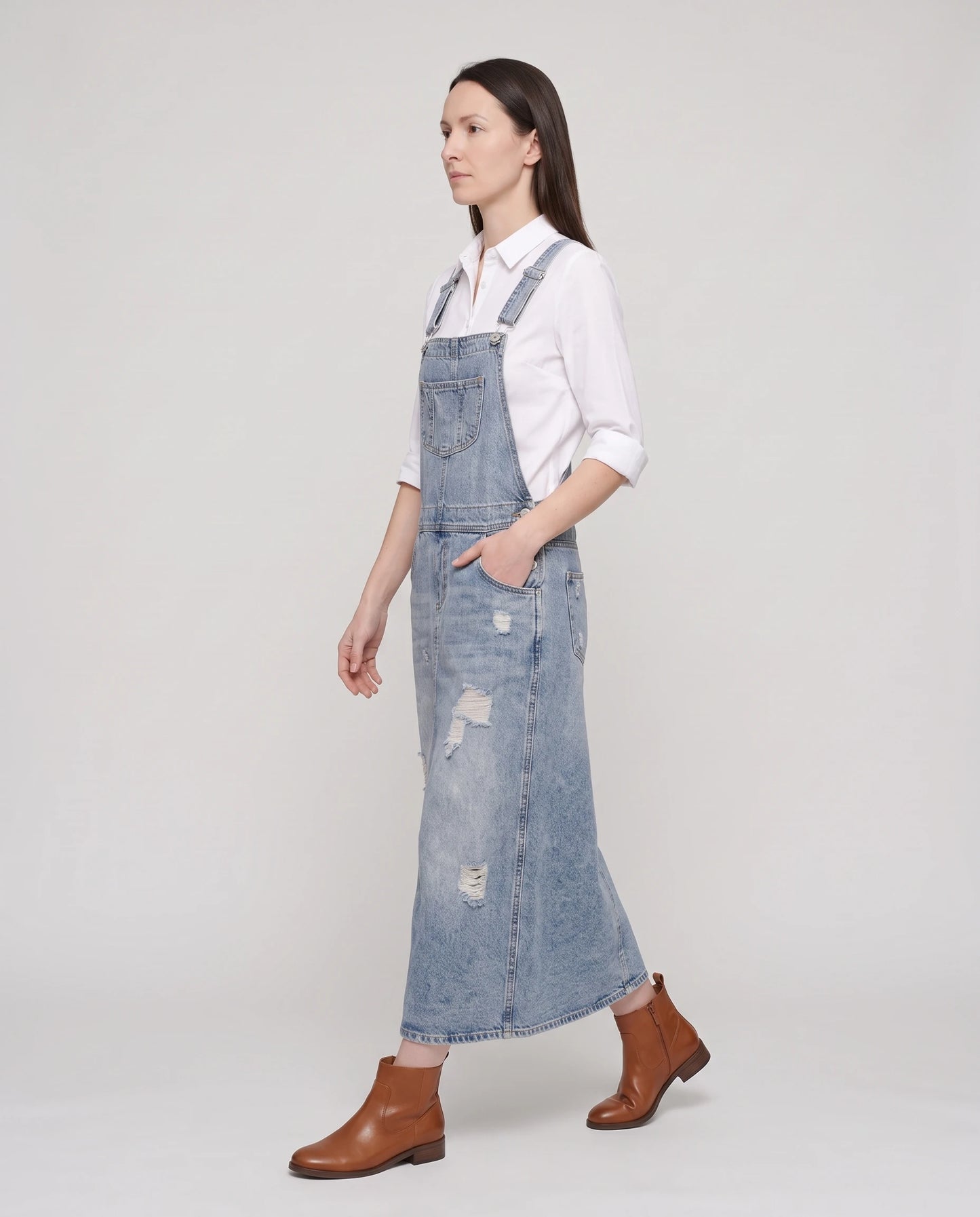 Robe salopette longue en denim Faubourg, coloris bleu clair, vue de profil en marche