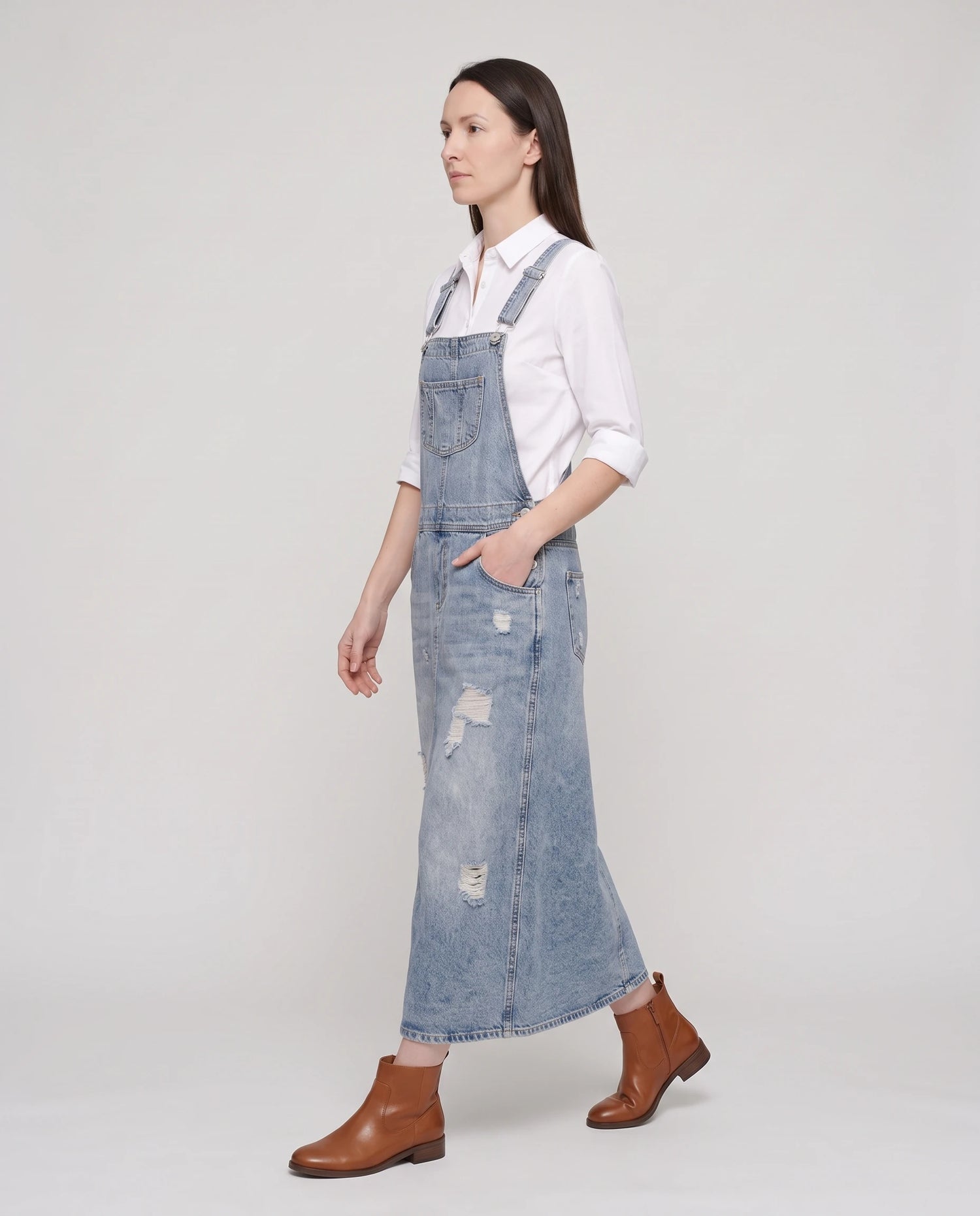 Robe salopette longue en denim Faubourg, coloris bleu clair, vue de profil en marche
