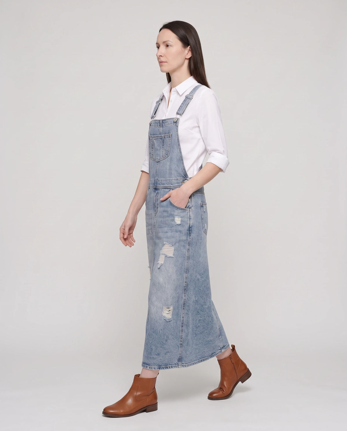 Robe salopette longue en denim Faubourg, coloris bleu clair, vue de profil en marche