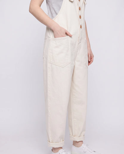 Salopette femme ample effet denim La Tournée, coloris blanc, détail des bretelles à œillets et de la bavette boutonnée