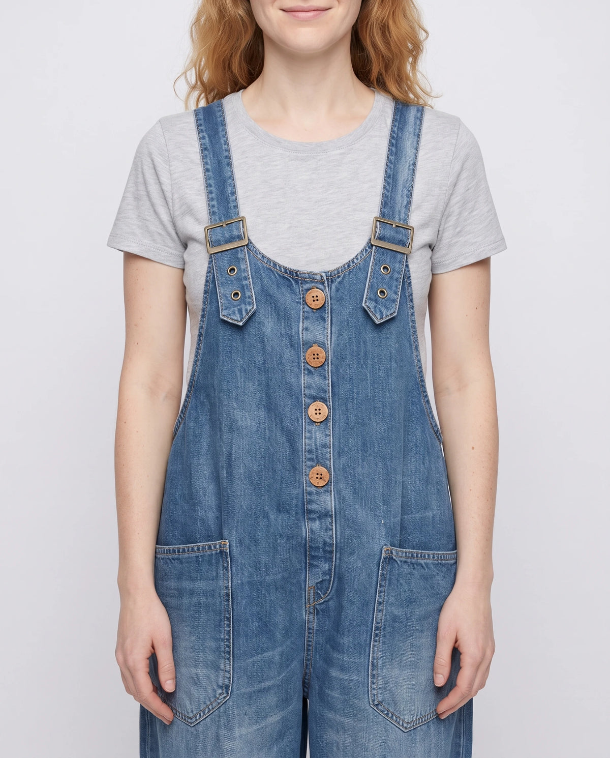Salopette femme ample effet denim La Tournée, coloris bleu, détail des bretelles à œillets et de la bavette boutonnée