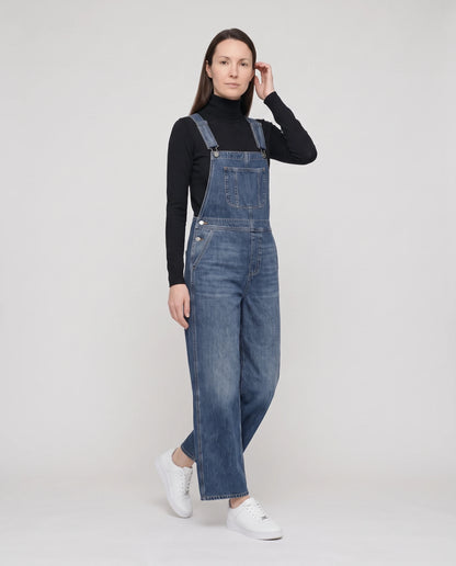 Salopette femme en denim jambes larges La Bourgeoise, coloris bleu foncé, vue de trois quarts en marche