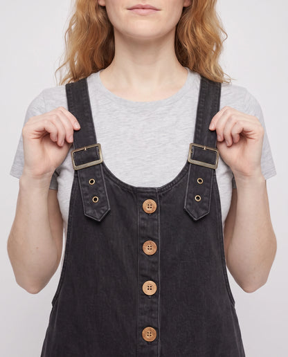 Salopette femme ample effet denim La Tournée, coloris noir, détail des bretelles à œillets et de la bavette boutonnée